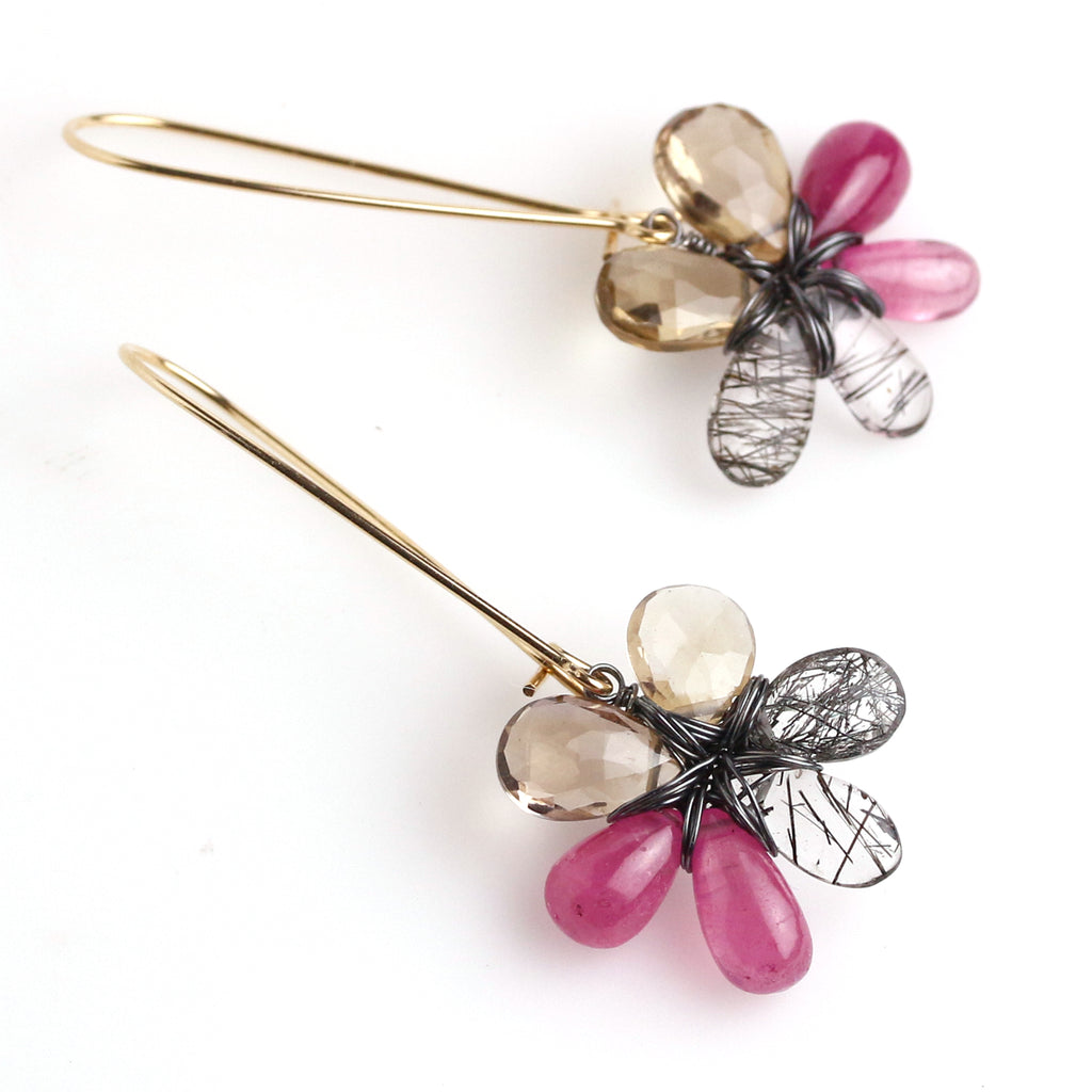 Another view of Pink, tan and black and white stone flower earrings hanging from long gold fill earwire.