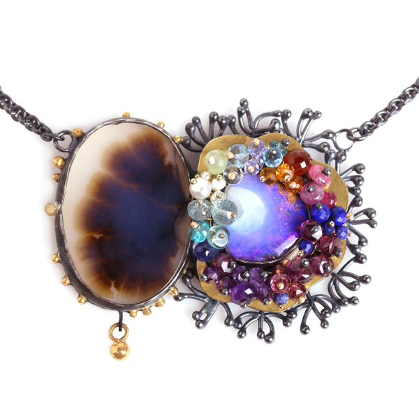 Pendant with split design: an oval agate the other side a gold setting with a  blue opal with colorful faceted gemstones.