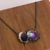 Same dendritic agate and blue opal pendant shown on a wood background.