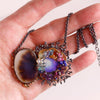 Same dendritic agate and opal pendant shown held in a hand for size reference.