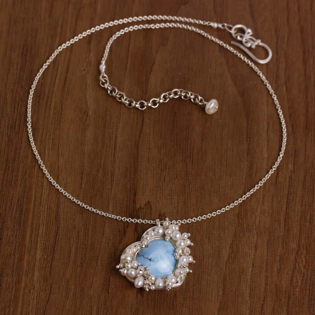 Turquoise heart pendant surrounded by clustered pearls on a silver chain.