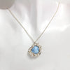 Turquoise heart pendant surrounded by clustered pearls on a silver chain.