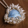 close up of Turquoise heart pendant surrounded by clustered pearls.